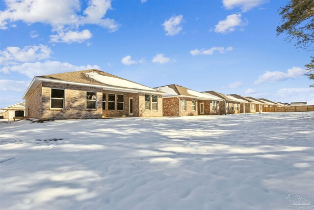 view of snow covered back of property