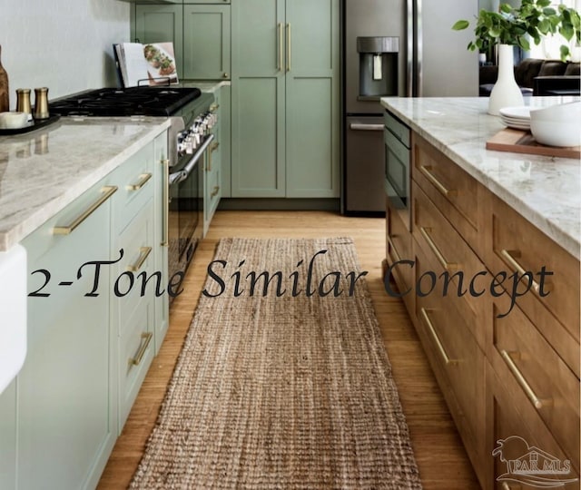 kitchen with light stone counters, green cabinets, light wood-style flooring, and appliances with stainless steel finishes