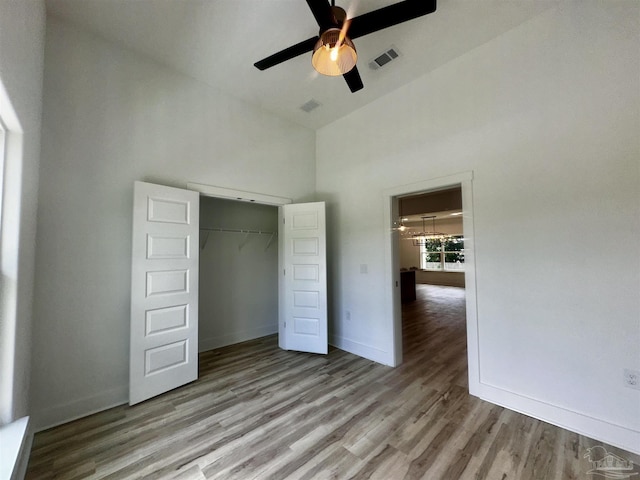 1181 Adrian Way, Milton, FL 32583 - unfurnished bedroom with wood finished floors, high vaulted ceiling, baseboards, a closet, and ceiling fan