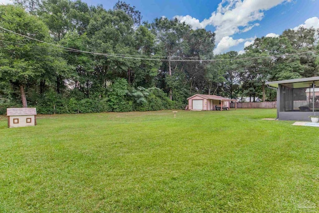 6028 Laurelwood Dr, Milton, FL 32570 - view of grassy yard featuring a sunroom and a detached garage