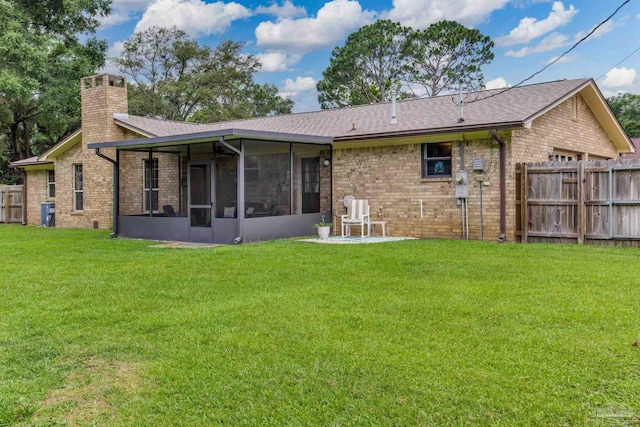 6028 Laurelwood Dr, Milton, FL 32570 - back of house with a chimney, a sunroom, brick siding, and roof with shingles