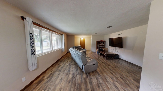 living room with dark hardwood / wood-style floors and a textured ceiling