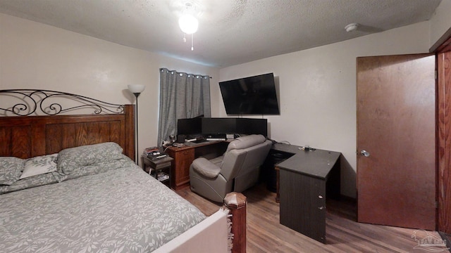 bedroom with a textured ceiling and wood finished floors