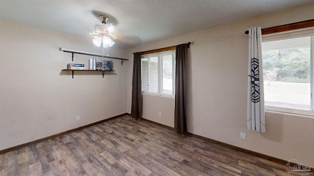 unfurnished room featuring baseboards and wood finished floors