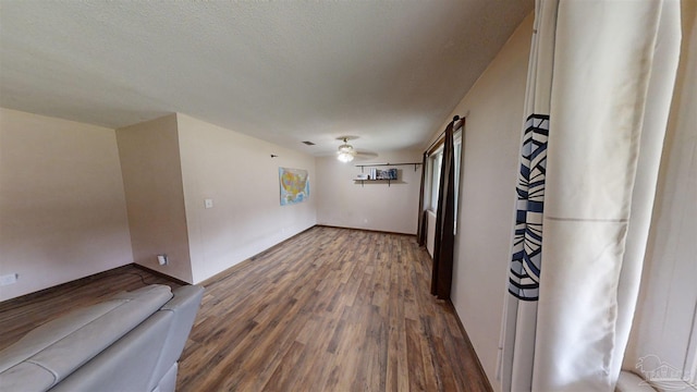 unfurnished room with ceiling fan, a textured ceiling, and wood finished floors