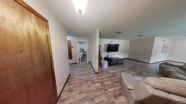 corridor featuring baseboards and wood finished floors