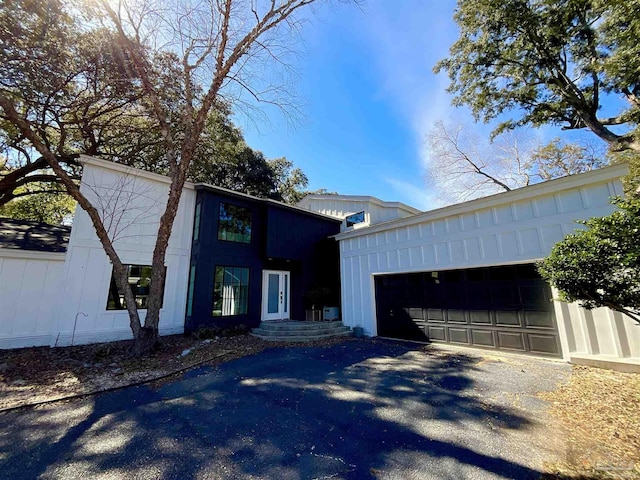 view of front facade with driveway, a garage, and board and batten siding