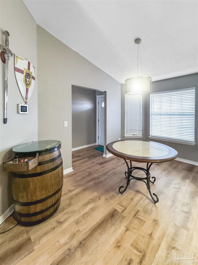 dining area with hardwood / wood-style flooring and vaulted ceiling