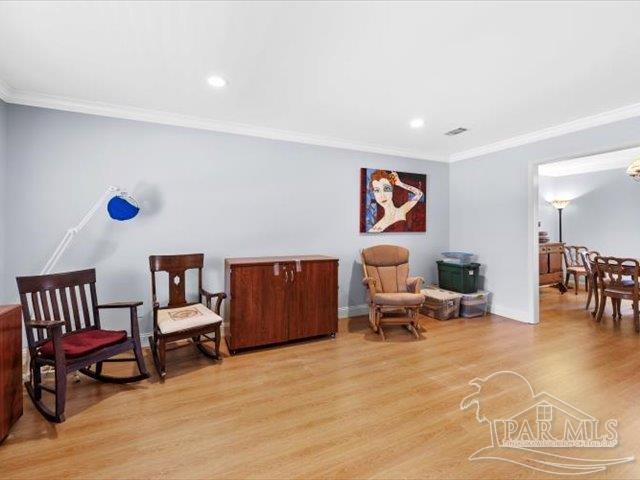 sitting room featuring crown molding and light wood-type flooring