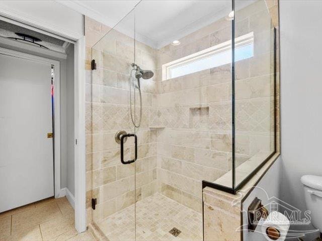 bathroom featuring tile patterned floors, toilet, and walk in shower