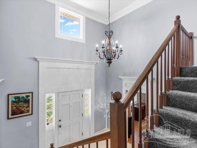 foyer entrance featuring crown molding and a chandelier