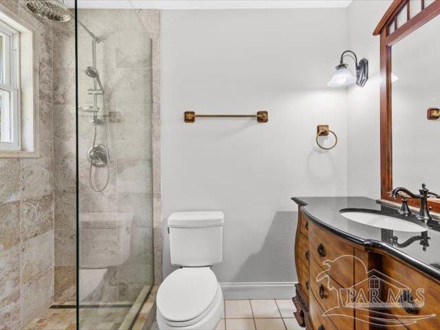 bathroom with vanity, toilet, an enclosed shower, and tile patterned flooring