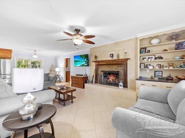 living room featuring ornamental molding, light tile patterned floors, and ceiling fan