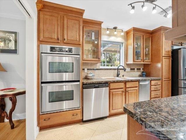 kitchen featuring dark stone countertops, sink, decorative backsplash, and stainless steel appliances