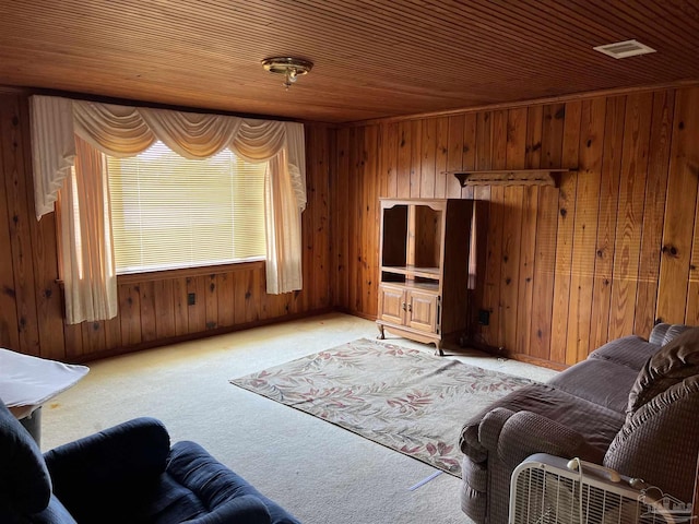 carpeted living room with wooden ceiling and wood walls