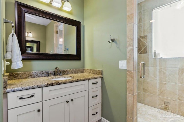 bathroom with a shower stall and vanity