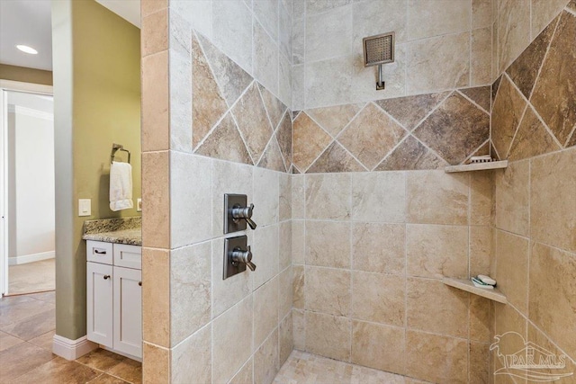 bathroom featuring a tile shower, vanity, and tile patterned floors