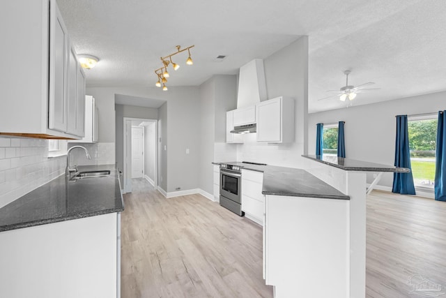 1548 Joseph Cir, Gulf Breeze, FL 32563 - kitchen with light wood-style flooring, a sink, under cabinet range hood, stainless steel range with electric cooktop, and a peninsula
