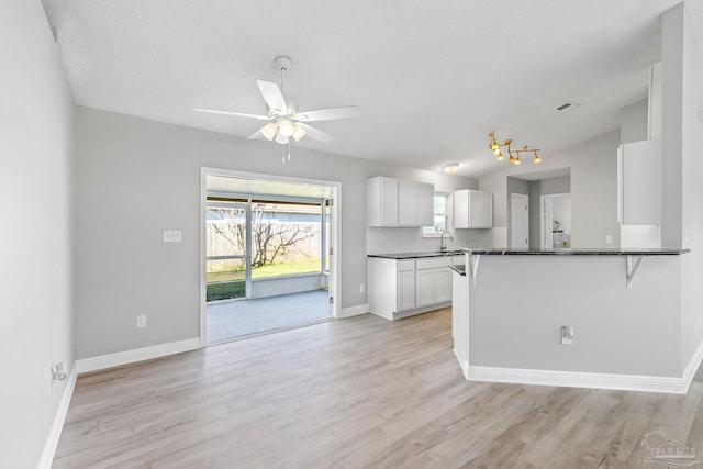 1548 Joseph Cir, Gulf Breeze, FL 32563 - kitchen with a sink, white cabinets, light wood finished floors, baseboards, and ceiling fan