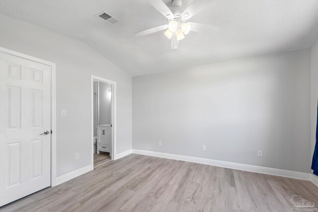 1548 Joseph Cir, Gulf Breeze, FL 32563 - unfurnished bedroom featuring visible vents, ensuite bath, light wood-style floors, baseboards, and vaulted ceiling