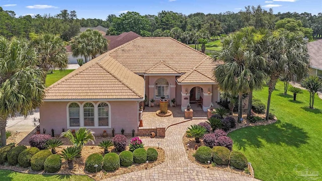 2792 Pga Blvd, Navarre, FL 32566 - view of front facade featuring a tile roof, a front yard, and stucco siding