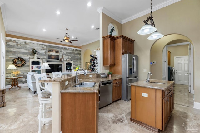 2792 Pga Blvd, Navarre, FL 32566 - kitchen featuring stainless steel appliances, a sink, arched walkways, a ceiling fan, and crown molding