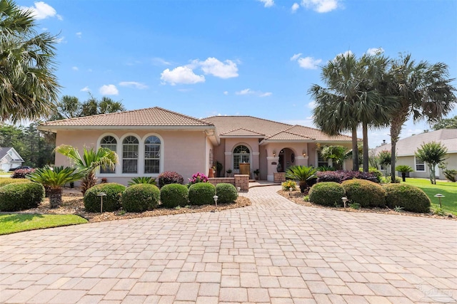 2792 Pga Blvd, Navarre, FL 32566 - mediterranean / spanish-style home featuring a tiled roof, stucco siding, and decorative driveway