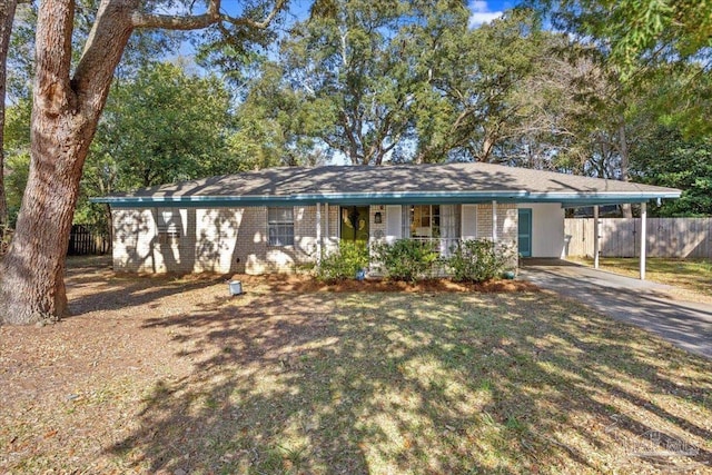 single story home featuring brick siding, an attached carport, concrete driveway, and fence