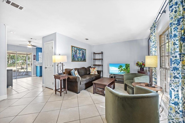 living area with light tile patterned floors, visible vents, and a ceiling fan