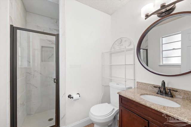 full bathroom featuring a stall shower, toilet, vanity, and a textured ceiling