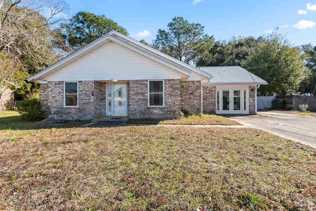 ranch-style home with a front lawn and french doors