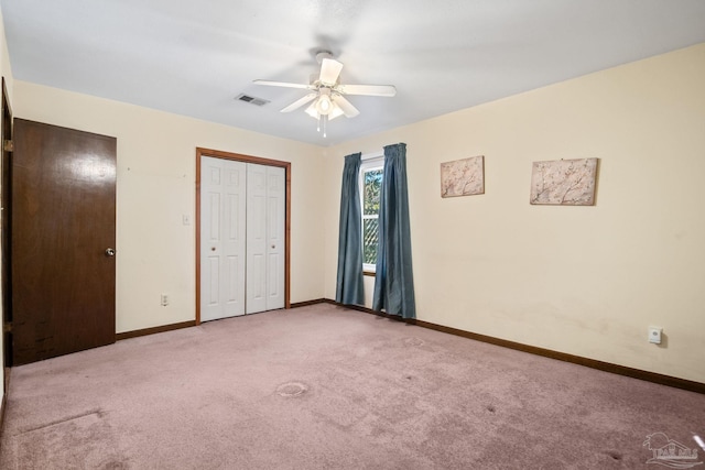 unfurnished bedroom with ceiling fan, light colored carpet, and a closet