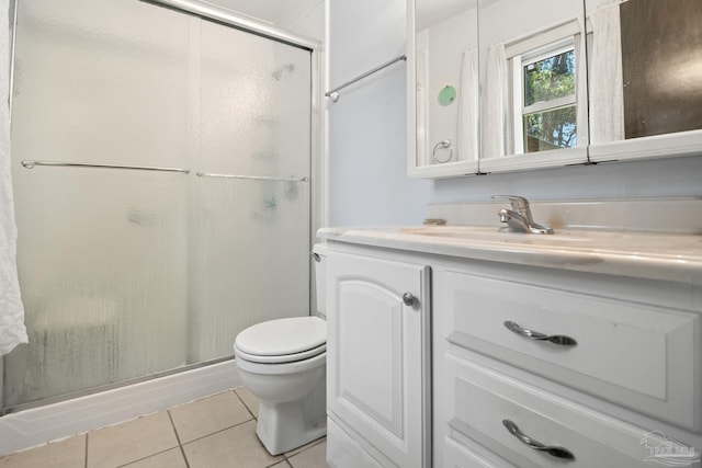 bathroom featuring walk in shower, vanity, toilet, and tile patterned flooring