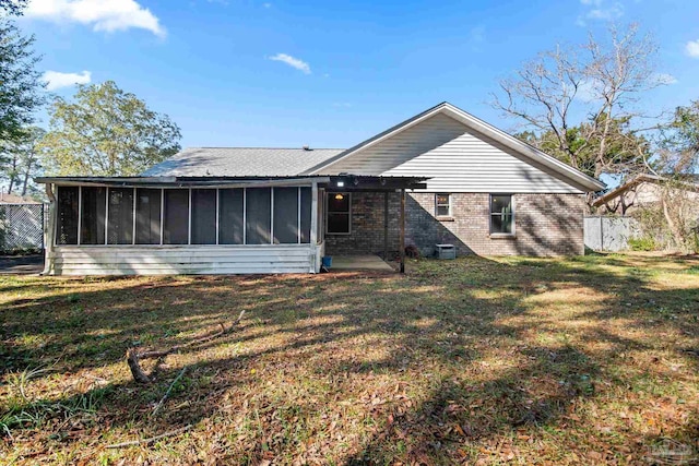 rear view of house featuring a patio, a yard, and a sunroom