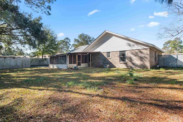 back of house with a lawn and a sunroom