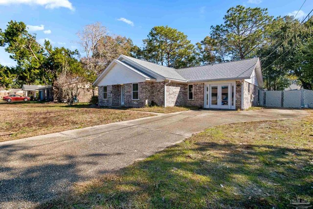 ranch-style house featuring a front lawn and french doors