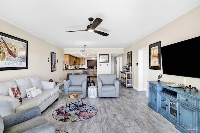 living room featuring ceiling fan with notable chandelier, light hardwood / wood-style floors, and crown molding