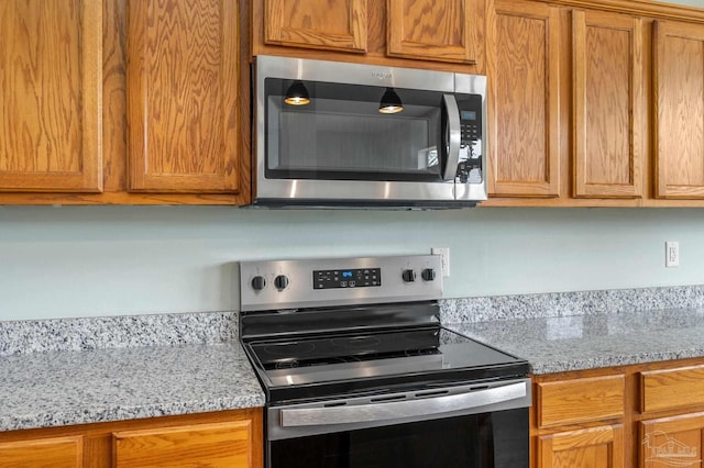 kitchen with light stone counters and stainless steel appliances