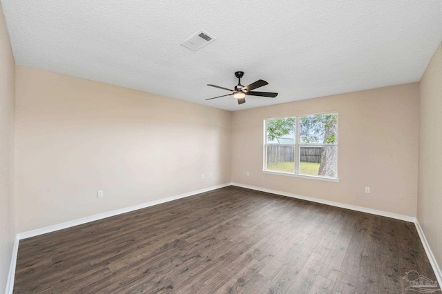 spare room featuring ceiling fan, dark wood-type flooring, and a textured ceiling