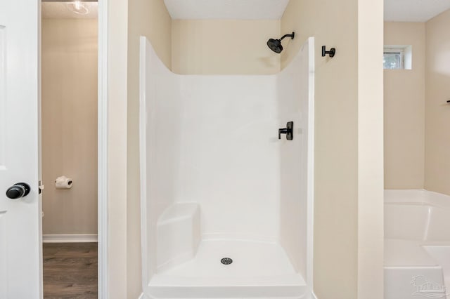 bathroom featuring hardwood / wood-style flooring, a shower, and a textured ceiling