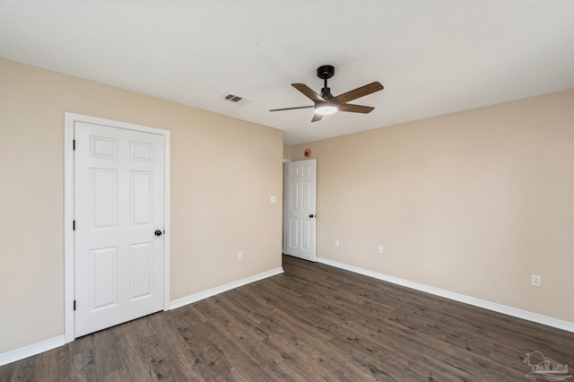 empty room with ceiling fan, dark hardwood / wood-style flooring, and a textured ceiling