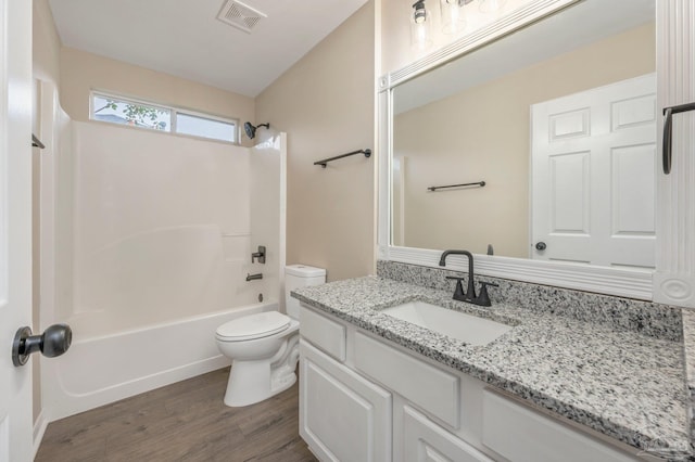 full bathroom with hardwood / wood-style flooring, shower / tub combination, vanity, and toilet