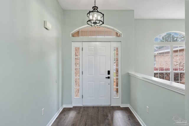 entryway with dark hardwood / wood-style flooring and a chandelier