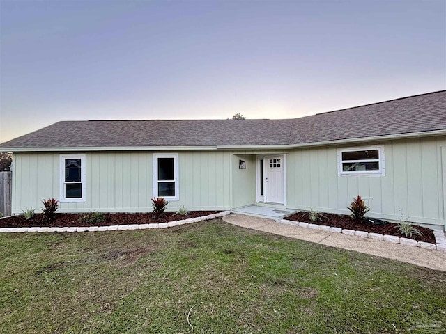 ranch-style home with a yard