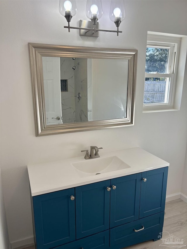 bathroom featuring hardwood / wood-style flooring, vanity, and a shower