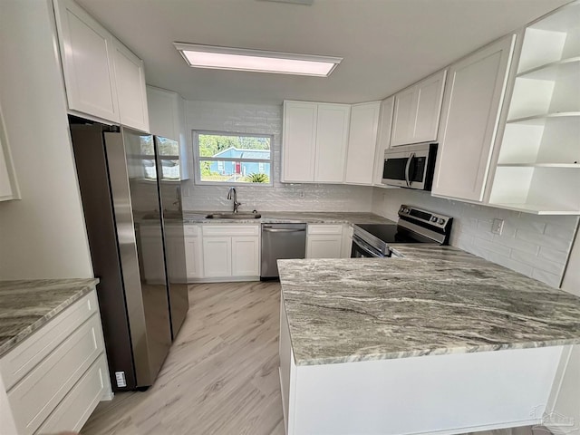 kitchen featuring white cabinetry, sink, stainless steel appliances, light stone counters, and light hardwood / wood-style flooring