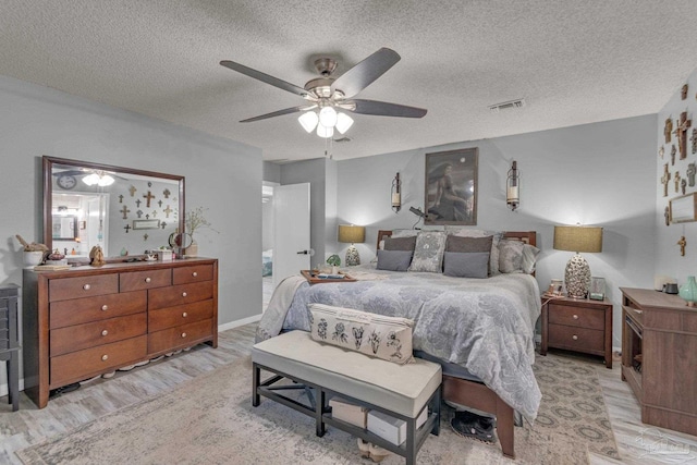 bedroom featuring a textured ceiling, ceiling fan, and light hardwood / wood-style floors