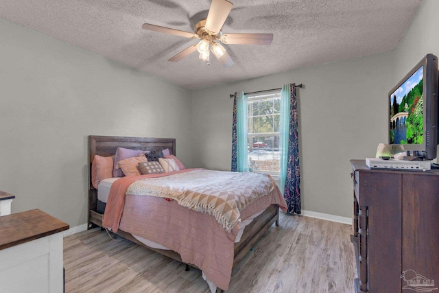 bedroom featuring a textured ceiling, ceiling fan, and light hardwood / wood-style flooring