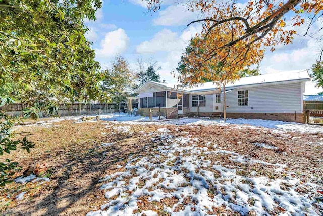 snow covered property featuring a sunroom