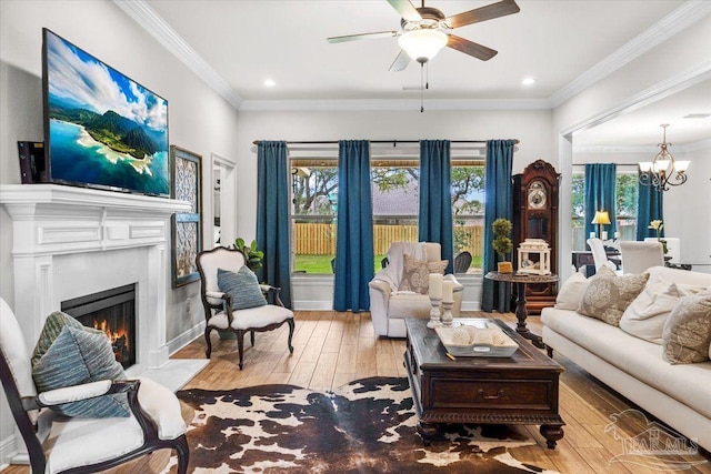 2219 River Birch Rd, Gulf Breeze, FL 32563 - living room featuring light wood finished floors, a chandelier, a fireplace with flush hearth, a ceiling fan, and ornamental molding